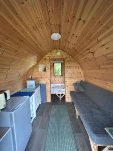 a kitchen and living room in a wooden cabin at Ronam Glamping 2 Berth Pod in Anderby