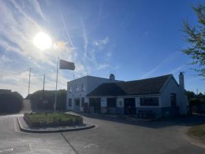 a white building with a flag in front of it at Ronam Glamping 2 Berth Pod in Anderby +1 photo