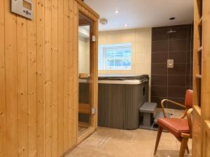 a bathroom with wooden walls and a sink and a tub at Luxury Georgian Townhouse Tenby Sleeps 8 Parking Permit in Tenby +66 photos