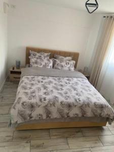 a bed with a black and white comforter and pillows at ARY Montan in Petroşani