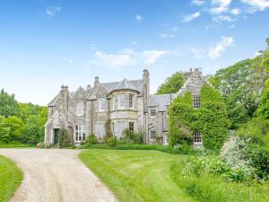 an old stone mansion with a dirt road at The Cottage in Slickly