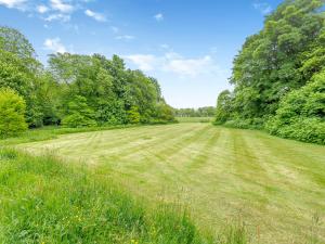 a large field of grass with trees in the background at The Cottage in Slickly