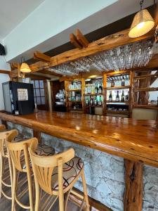 a bar with a wooden counter and some chairs at Hostería Cumbres Blancas in Esquel +12 photos