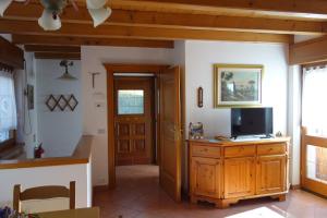 a living room with a tv on a wooden cabinet at Fabbricato Indipendente Centro in Lozzo Cadore