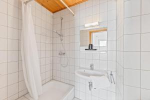 a white tiled bathroom with a shower and a sink at Monteurapartments in Heidenheim NEU Küche Smart TV WIFI in Heidenheim an der Brenz +43 photos