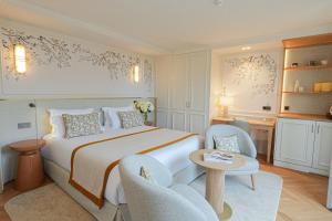 a hotel room with a bed and two chairs at Relais d'Amboise - The Leading Hotels of the World in Amboise