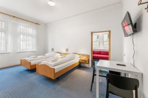 two beds in a room with a table and a desk at Monteurapartments in Heidenheim NEU Küche Smart TV WIFI in Heidenheim an der Brenz