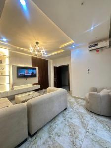 a living room with two couches and a tv at One bedroom apartment Presidential suite in Abuja +6 photos