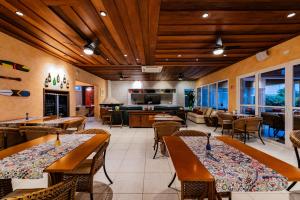 a restaurant with wooden ceilings and tables and chairs at Pousada Alcatrazes in Juquei