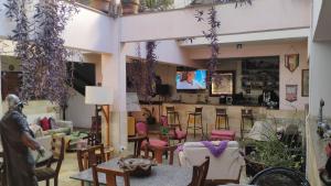 a living room with tables and chairs and a tv at Sollarium GINI Suítes in Guarapari