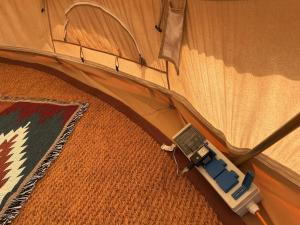 an electronic device is plugged into the inside of a tent at Wild Meadow Camping in Llandysul