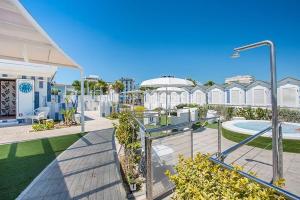 a building with a walkway in front of a yard at Hotel Garden in Riccione