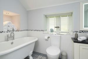 a white bathroom with a tub and a toilet and a sink at 3 Bed in Dalwood oc-p27362 in Dalwood +21 photos
