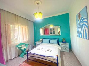 a bedroom with a bed and a blue wall at Garden House Katerini in Katerini