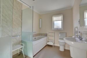 a bathroom with a tub and a sink and a toilet at 2 Bed in Attleborough oc-1277 in Old Buckenham +4 photos