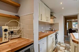 a kitchen with white cabinets and wooden counter tops at 2 Bed in Dersingham oc-p28040 in Dersingham +15 photos