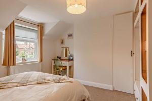 a bedroom with a bed and a desk and a window at 2 Bed in Dersingham oc-p28040 in Dersingham