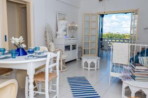 a white dining room with a table and chairs at Spitaki by the Sea in Paralimni