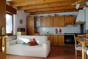 a living room with a white couch in a kitchen at Fabbricato Indipendente Centro in Lozzo Cadore