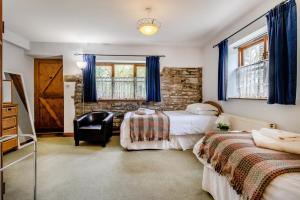 a bedroom with two beds and a chair in it at 3 Bed in Knighton oc-b29329 in Felindre