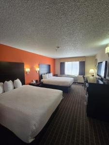 a hotel room with two beds and a flat screen tv at Howard Johnson by Wyndham Williams in Williams +18 photos