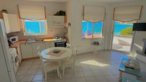a kitchen with a table and a table and chairs at Infinity View Villa Panoramic Aegean Siviri in Siviri