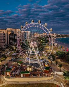 a ferris wheel on the beach at night at Pousada Corais de Pajuçara- MCZ in Maceió +13 photos