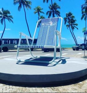 a chair sitting on a circle in front of the beach at Pousada Corais de Pajuçara- MCZ in Maceió