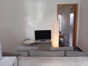 a living room with a couch and a television at Apartamentos São Sebastião in Évora