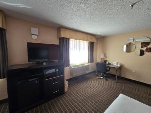a hotel room with a television and a desk at Howard Johnson by Wyndham Williams in Williams