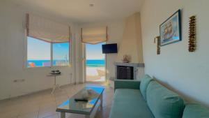 a living room with a blue couch and a view of the ocean at Infinity View Villa Panoramic Aegean Siviri in Siviri
