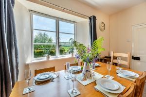 a dining room with a wooden table and a window at 3 Bed in Filleigh oc-b28914 in West Buckland