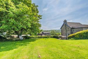 an old stone house with a tree and a yard at 3 Bed in Filleigh oc-b28914 in West Buckland