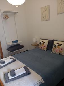 a bedroom with a bed with a blue blanket and pillows at Apartamentos São Sebastião in Évora