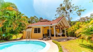 a villa with a swimming pool in front of a house at Caribbean Hill Villas in Cocles