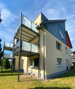a building with a balcony with a clock on it at Midi-Maisonette mit kleiner Dachterrasse und Blick ins Grüne in Petersberg