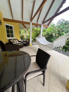 a patio with a hammock and a table and chairs at Caribbean Hill Villas in Cocles +1 photo