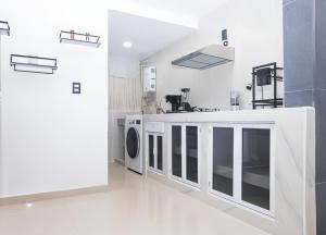 a white kitchen with a washing machine in a room at condominio los mangos in Santa Cruz Huatulco