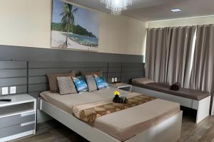 a bedroom with a large bed and a desk at Cobertura com piscina, sauna e churrasqueira in São Pedro da Aldeia