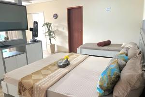 a living room with two beds and a flat screen tv at Cobertura com piscina, sauna e churrasqueira in São Pedro da Aldeia +24 photos