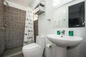 a white bathroom with a sink and a toilet at La Estancia del Abuelo in Cusco