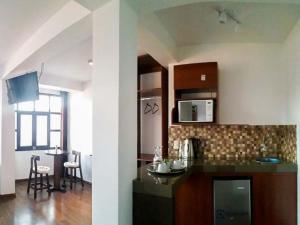 a kitchen with a counter and a table in a room at La Estancia del Abuelo in Cusco