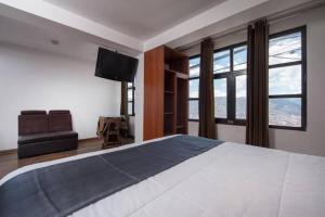 a bedroom with a bed and a flat screen tv at La Estancia del Abuelo in Cusco