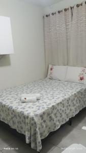 a bed with two white towels on top of it at Pousada Santos 4, kitnet confortável com ar condicionado in Londrina