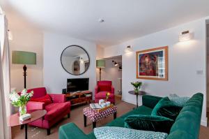 a living room with red and green furniture and a mirror at 4 Bed in Walmer oc-c29264 in Deal