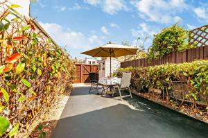 a patio with a table and an umbrella at 4 Bed in Walmer oc-c29264 in Deal