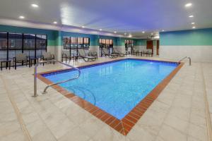 a pool with tables and chairs in a building at Holiday Inn Express Hotel & Suites Lonoke I-40 by IHG in Lonoke