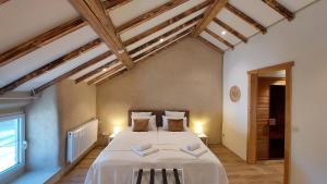 a bedroom with a large bed in a room with wooden ceilings at Refuge des Sottais in Burg-Reuland