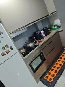 a kitchen with a stove and a refrigerator at Quarto casal Px aeroporto Garagem in Cascavel