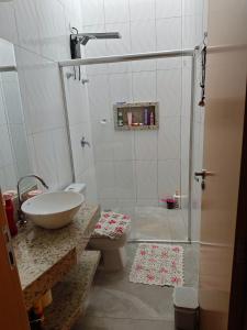 a bathroom with a shower with a sink and a toilet at Quarto casal Px aeroporto Garagem in Cascavel